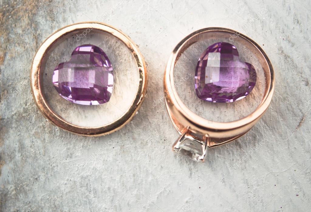 Dos anillos decorativos con piedras plateadas y un espejo sobre la mesa