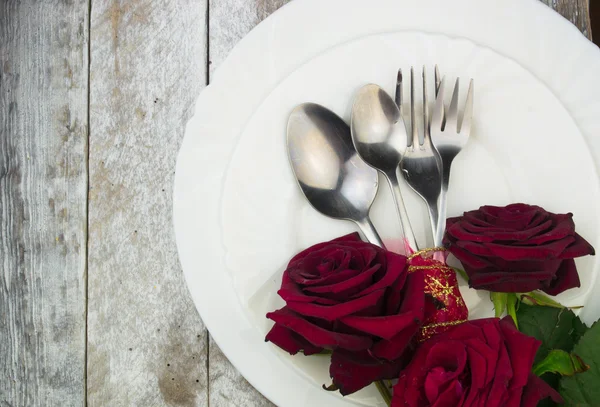 Накрытие стола с красными розами на фоне белого дерева — стоковое фото