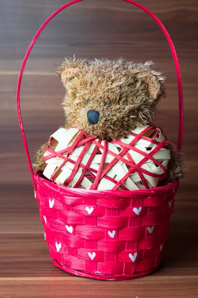 Osito de peluche de San Valentín en la canasta de mimbre sobre fondo de madera — Foto de Stock