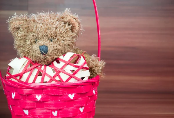 Osito de peluche de San Valentín en la canasta de mimbre sobre fondo de madera — Foto de Stock