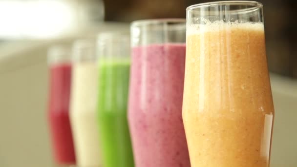 Wiele różnorodnych smoothie stoi na stole w szklance — Wideo stockowe