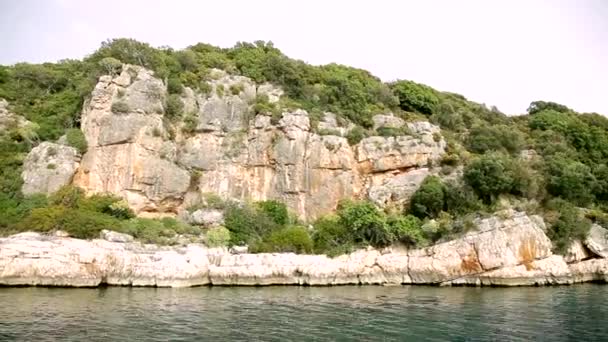El yate flota junto a las rocas — Vídeo de stock