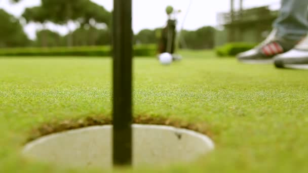 Jogador de golfe golpeia bola no campo de golfe — Vídeo de Stock