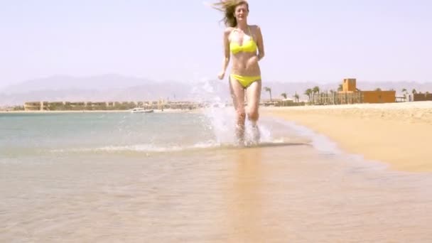 Девушка бежит по пляжу — стоковое видео