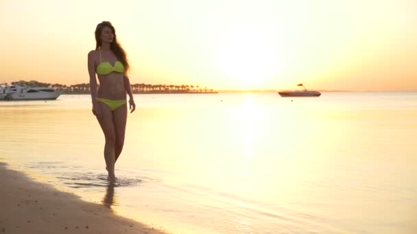 Menina andando perto do mar ao pôr do sol — Vídeo de Stock