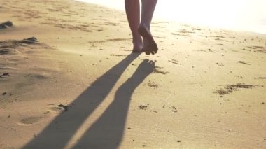 Kadın ayakları akış boyunca kum denize doğru. HD