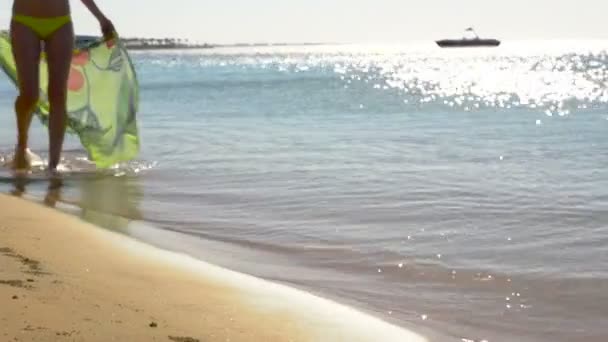 Weibliche schöne Beine gehen mit Pareo über das Meer. hd — Stockvideo