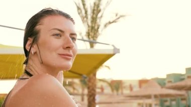 Bir kız havuz başında açık havada bir duş alıyor. HD