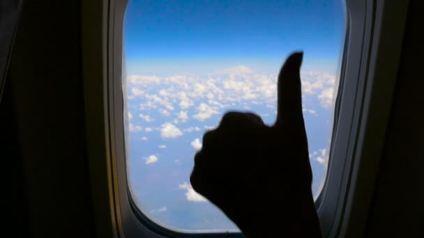 Ручная девочка показывает жест в порядке на фоне окна самолета. HD — стоковое видео