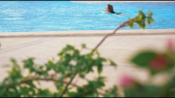 Attraktiv kvinna simmar i en pool. HD — Stockvideo