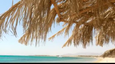 Hasır bir şemsiye ile deniz manzarası. 4k