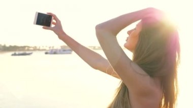 Güzel kız selfie gün batımında yapıyor. HD