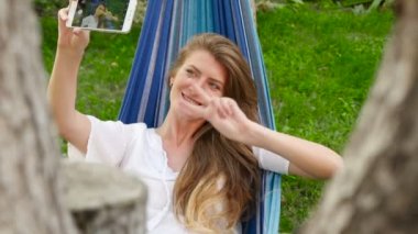 Güzel model bir hamakta yatan selfie yapma. HD