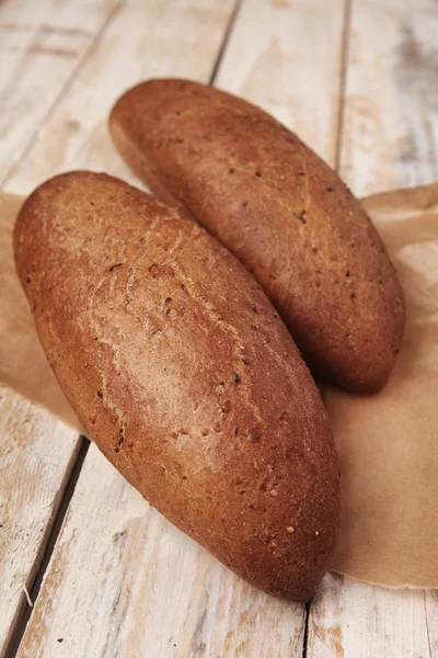 Dois loafs de pão feito à mão em uma mesa de madeira  . Imagem De Stock