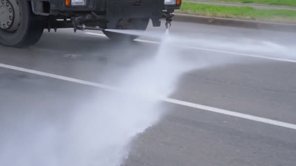 Municipality big vehicle washing city asphalt road with water splashing — Stock Video