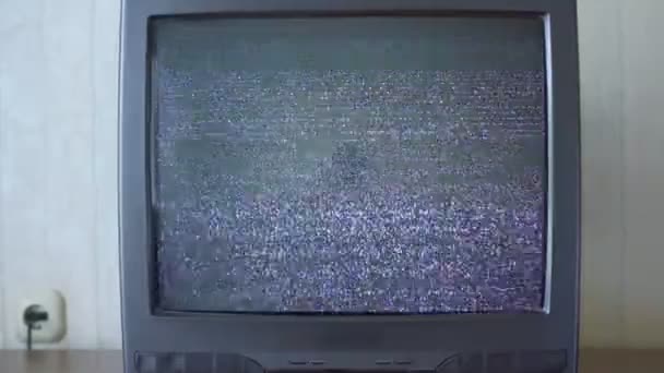 Schermo televisivo in piedi sulla scrivania e mostrando immagine video rumore — Video Stock