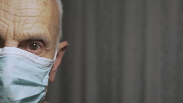 Demi-visage de l'homme âgé portant masque avec des yeux tristes concept de soins de santé — Video