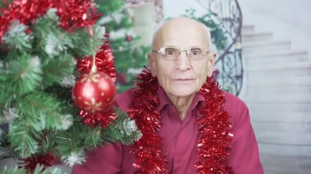 Old hoary bald man in eyeglasses has facetime with family in Christmas eve — Stock Video