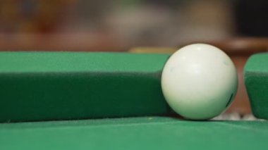 Beyaz bilardo topu diğer topu tekmeliyor ve potaya düşüyor.