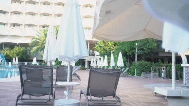 Beyaz şemsiyeli ve havuzlu boş otel bölgesi.