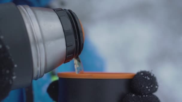 Mann hält Thermoskanne in der Hand und gießt heißen Tee in Becher — Stockvideo