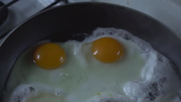 2つの大きな卵黄と揚げ卵は、迅速な朝食のためのフライパンで揚げられています. — ストック動画