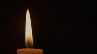 Siyah odada parlak sarı mum alevini kapat.