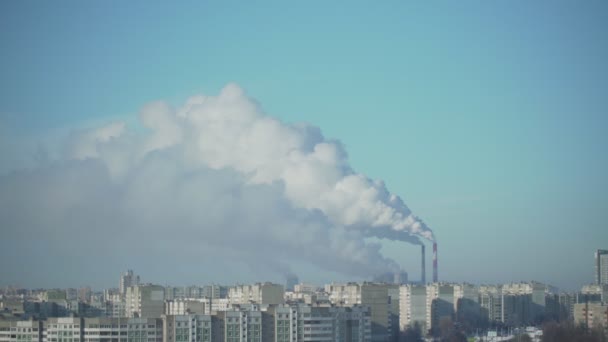 Humo blanco de las chimeneas de la fábrica gira en el cielo azul sobre la ciudad — Vídeos de Stock