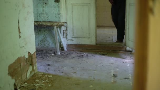 ジーンズの男は古い放棄された家の木製の床の上を歩く. — ストック動画