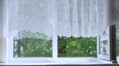 Hafif yaz meltemi açık pencereden sarkan ince beyaz perdeyi sallıyor.