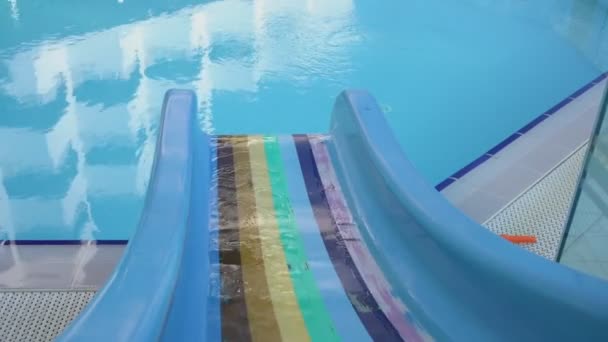 Вода медленно течёт из пластмассового многоцветного горки. — стоковое видео