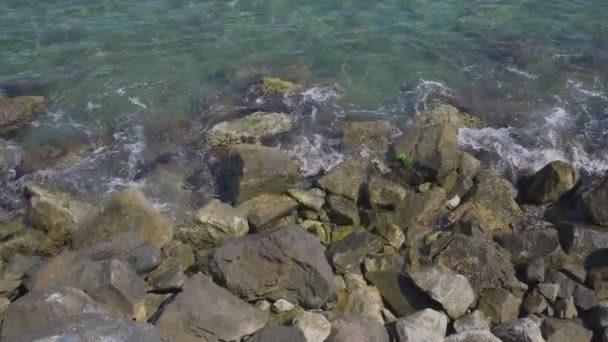 Zeegolven breken af op de kust van de baai rotsen tijdens de zee surfen. — Stockvideo