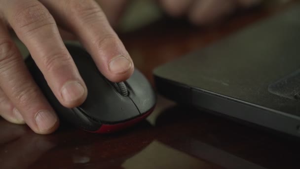 Зморщена рука літнього чоловіка, що тримає комп'ютерну мишу на столі вдома . — стокове відео