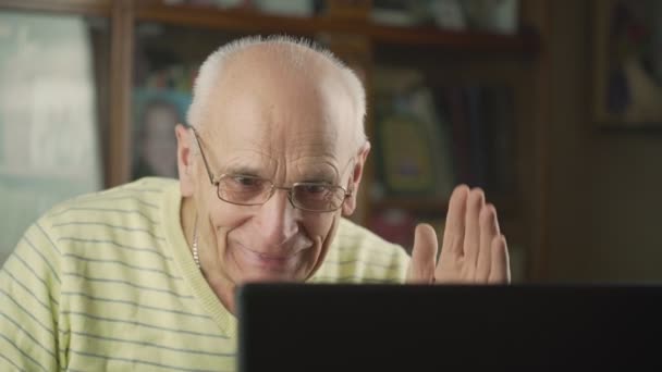 Senior man wearing eyeglasses has online video call with family — Vídeo de Stock