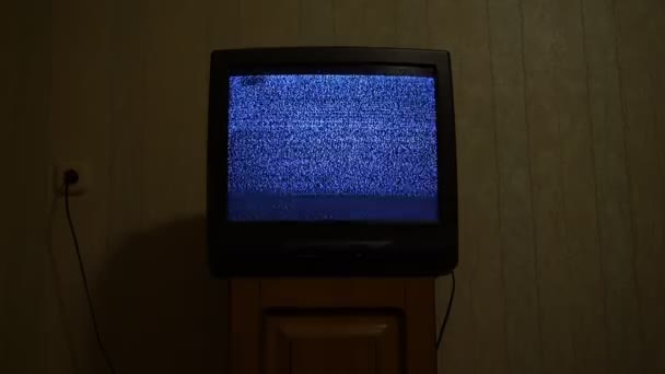 Old retro tv with glitch snowy broadcast stands on wooden bedside table — Stock Video