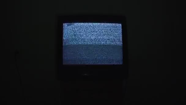 Broken tv screen with noise analog static signal in black room at night — Stock Video