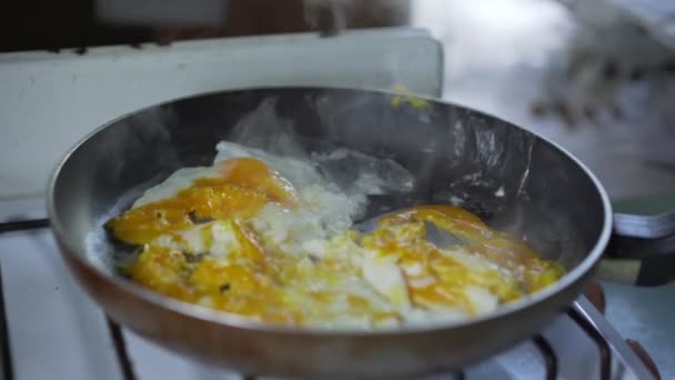 Mano rugosa dell'uomo che apre il coperchio della padella e sale uova fritte su padella rustica — Video Stock