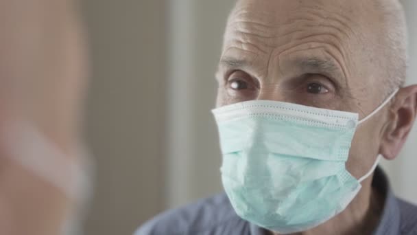 Älterer Mann mit medizinischer Gesichtsmaske blickt im Spiegelbild in Pflegeheim. — Stockvideo