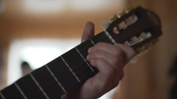 Macho dedos agarre cuerdas de guitarra para golpear el acorde con la barra de primer plano — Vídeos de Stock