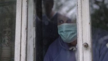 Oğlu, huzurevinde yaşlı ve hasta babasını ziyaret eder ve pencere camının arkasında buluşur.