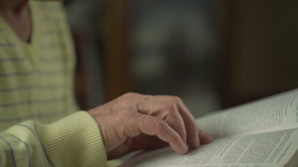 Hombre mayor siga el texto del libro con la mano arrugada vista cercana — Vídeo de stock