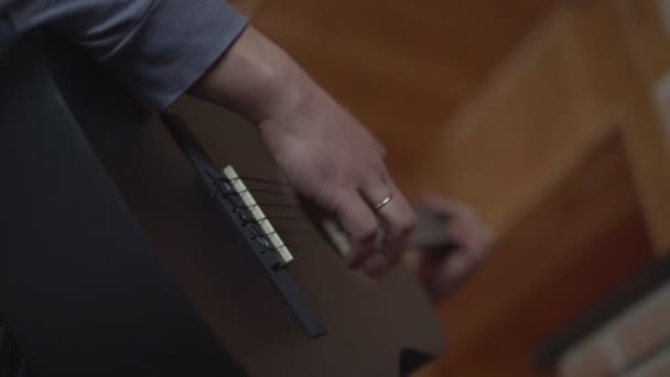Человек с золотым кольцом на пальце играет на гитаре — стоковое видео
