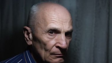 Yüzünü çeviren kızgın, somurtkan, yaşlı bir adamın geniş ölçekli portresi.