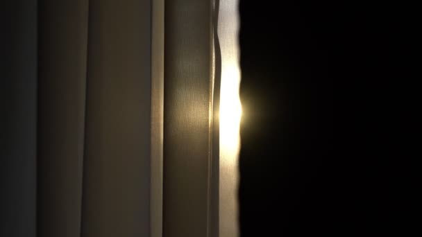 Heller Sonnenstrahl scheint durch Textilvorhang, der an großem Fenster hängt — Stockvideo