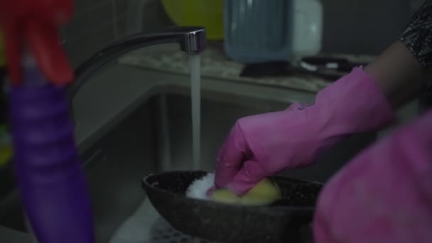 流水の下でフライパンを閉じる女性の手を洗う — ストック動画