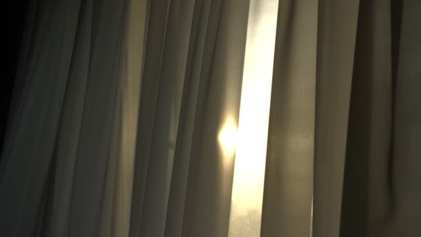 Длинные занавески серого цвета махали ветром против солнечного света — стоковое видео