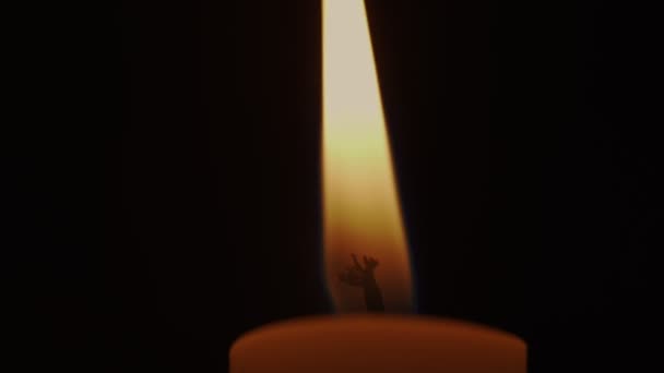 Helle Kerzenflamme brennt auf Denkmal in dunklem Raum. — Stockvideo