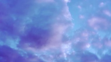 Paraşüt atlayışı sırasında mavi gökyüzünde dönen büyük gri ve beyaz bulutlar..