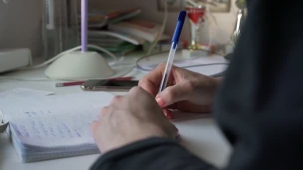 Gadis remaja dengan manikur memegang pena di tangan dan menulis PR. — Stok Video