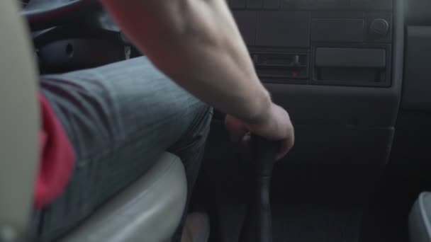 Человек водит грузовик с ручной коробкой передач и переключает передачу рукой — стоковое видео